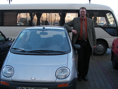 Eastern Europe--Ken Leaning on a European city commuter car.